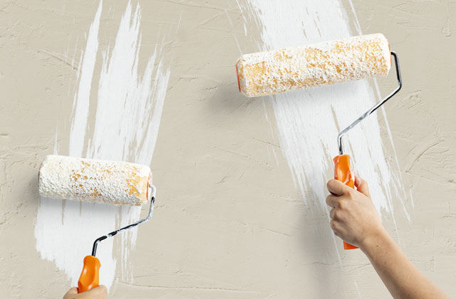 Handwerker bei der Arbeit, Streichen einer Wand, Maler übernimmt einen weißen Anstrich
